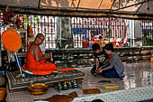 Bangkok Wat Arun - Buddist monk with visitors making merit. 